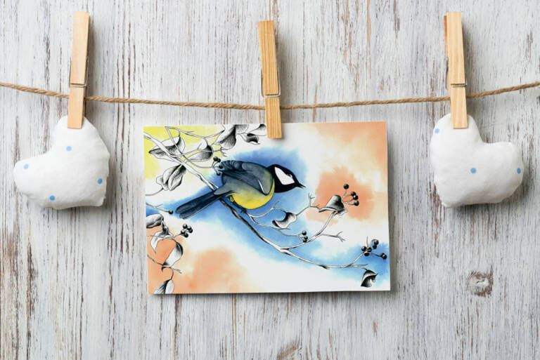 Carte illustrée d'une mésange charbonnière sur une branche avec des baies, style aquarelle et encre, fond bleu et orange pastel