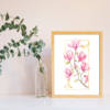 Affiche murale illustrée d'une branche de magnolias roses en aquarelle, fond blanc, cadre doré, style floral délicat