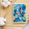 Carte illustrée de deux carpes koï rouges et blanches nageant parmi des nénuphars verts et des lotus roses, style aquarelle, fond bleu