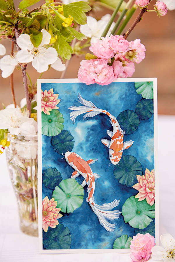 Carte illustrée de deux carpes koï rouges et blanches nageant parmi des nénuphars verts et des lotus roses, style aquarelle, fond bleu